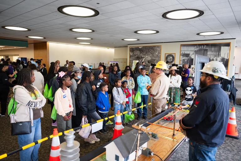 Students look on while LADWP staff perform a downed-wire demonstration.