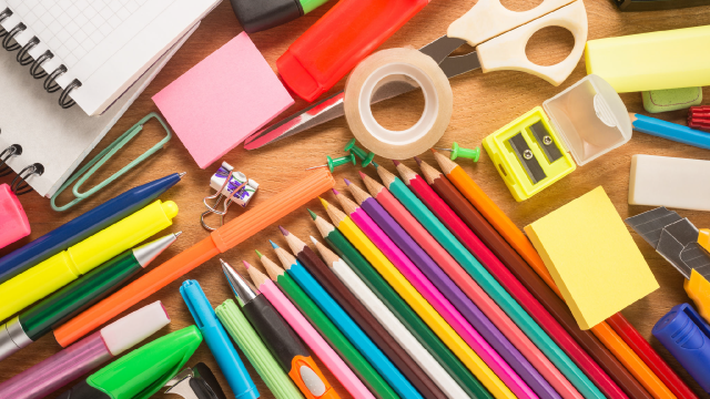 School supplies including scissors, tape, post-it notes, colored pencils, notebooks, pens, and highlighters