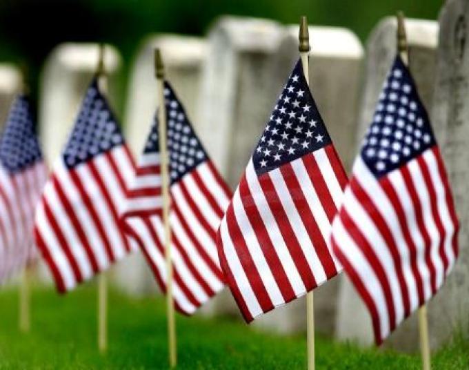 American flags in front of tombstones.