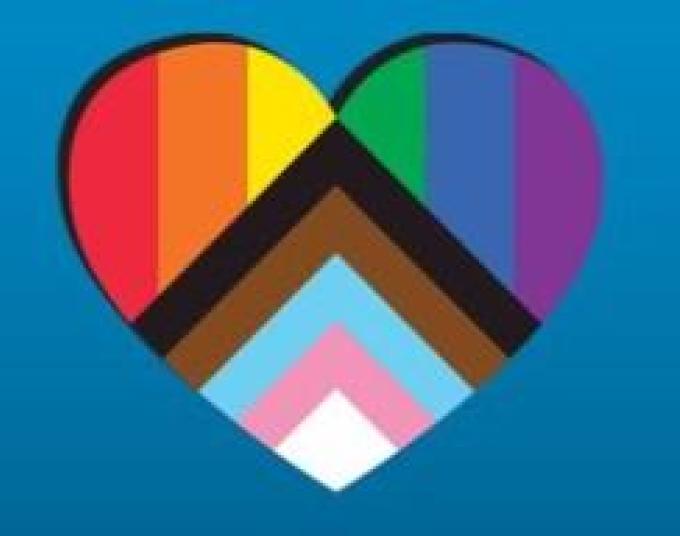 Heart with rainbow colors as well as black, brown, light blue, pink and white. Behind the heart is a blue background.