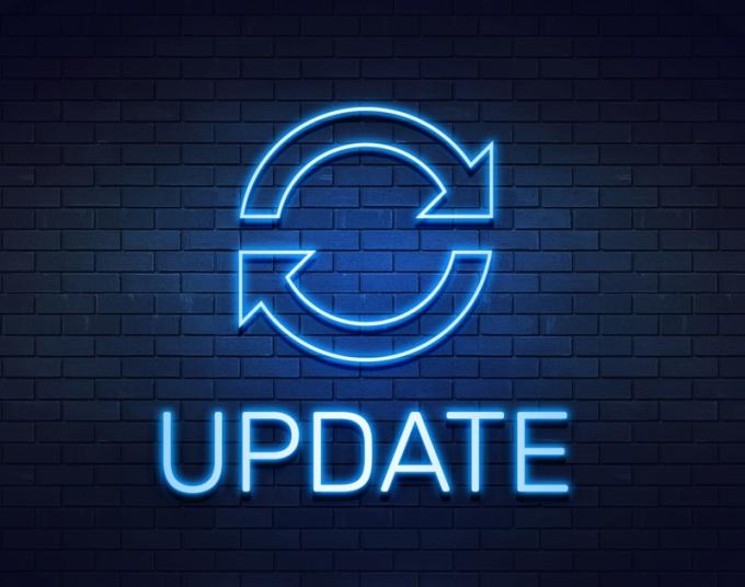 A neon light in the shape of the “update” icon is shown against a brick wall, with the word UPDATE below.