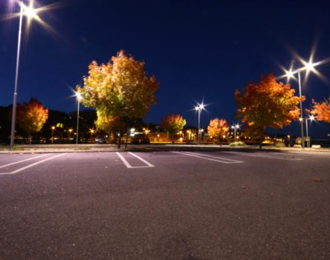 LED lights illuminate a parking lot at night.