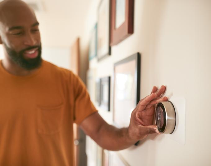 A man adjusting a thermostat