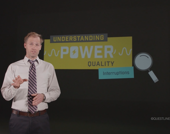 A businessman stands in front of a graphic that says: Understanding Power Quality - Interruptions