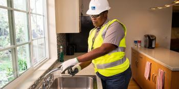 Woman installing a water aerator to a sink faucet.